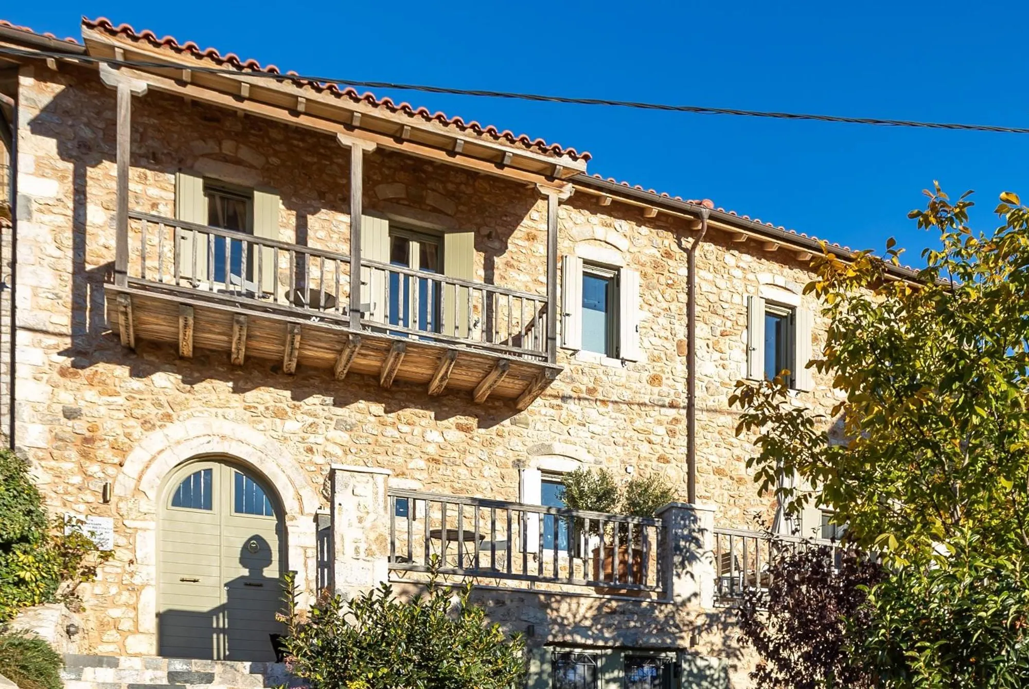 Η πέτρινη πρόσοψη με το ξύλινο μπαλκόνι
